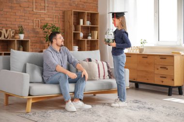 Babası ve kızı evde havan topu kavanozunda COLLEGE mesajı tutuyorlar. Okul harcı konsepti