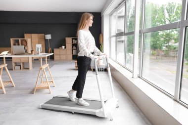 Ofisteki koşu bandında genç iş kadını eğitimi