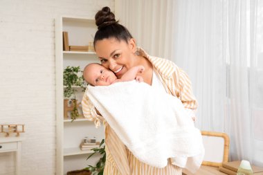 Güzel, genç, mutlu bir anne ve evde banyo yaptıktan sonra küçük şirin bir bebek.