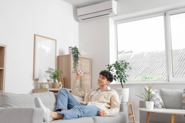 Genç adam çalışma odasındaki kanepede dinleniyor.