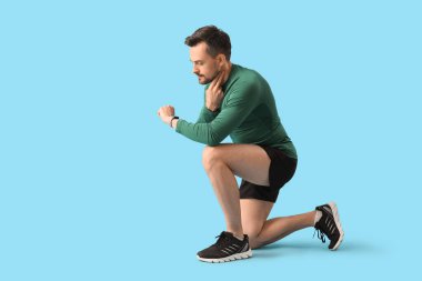 Zeki, genç bir adam mavi arka planda nabzını kontrol ediyor.