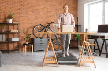 Ofisteki koşu bandında genç iş adamı eğitimi