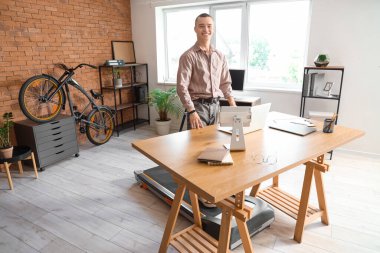 Ofisteki koşu bandında genç iş adamı eğitimi