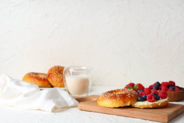 Beyaz arka planda tereyağlı ve böğürtlenli ahşap simit tahtası