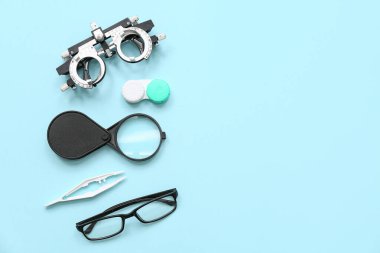 Gözlüklü optik deneme çerçevesi, kontak lensler ve mavi arka planda büyüteç için ayarlandı