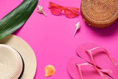 Parmak arası terlik, güneş gözlüğü, yeşil yaprak, pembe arka planda şapka ve samandan yapılmış çerçeve.