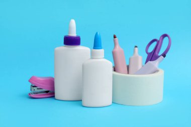 Mavi arka planda tutkal, işaret ve makas şişeleri