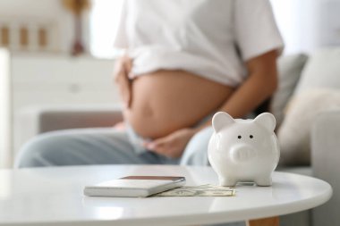 Kumbarada hesap makinesi ve para var. Yakın plan. Annelik Faydası konsepti