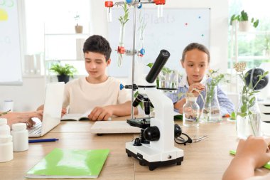 Modern mikroskop masa üzerinde ve öğrenciler okulda biyoloji dersinde, yakın çekim