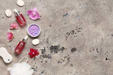 Esaslı yağ şişeleri, spa aksesuarları ve grunge arkaplanda orkide çiçekleri olan kompozisyon