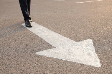 İşadamı ok iziyle yol boyunca yürüyor. Kariyer seçimi kavramı