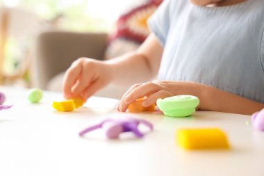 Masada plastikten heykel yapan sevimli küçük kız, yakın plan.