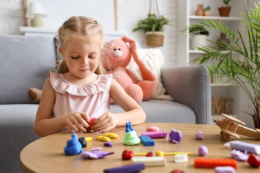 Evde plastikten heykel yapan sevimli küçük kız.