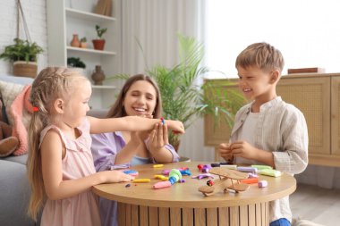 Evde plastikten heykel yapan anneleri olan sevimli küçük çocuklar.