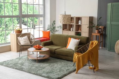 Konforlu kanepe, koltuklar ve sepet. Oturma odasının iç tarafındaki sehpada kayısı var.