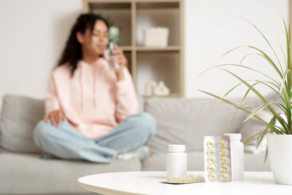 Bottles and blisters with fish oil on table in room