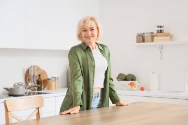 Mutfakta orta yaşlı bir kadın.