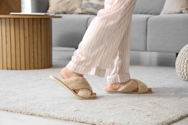 Terlikli bir kadın evdeki yumuşak halıda yürüyor, yakın plan.