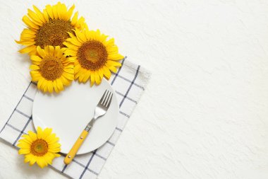 Beyaz arkaplanda ayçiçekleri olan güzel masa ayarları