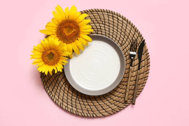 Pembe arka planda ayçiçekleri olan güzel bir masa.