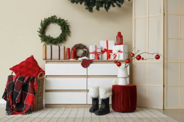 İçinde Noel çelenkleri, çekmeceleri ve puf olan bir oda.