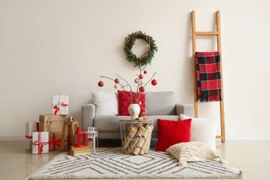 Oturma odasının içinde kanepe, merdiven ve Noel hediyeleri.