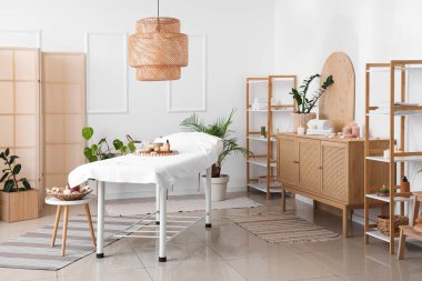 Masaj koltuğu, yanan mumları ve raf üniteleri olan bir kaplıca salonu.