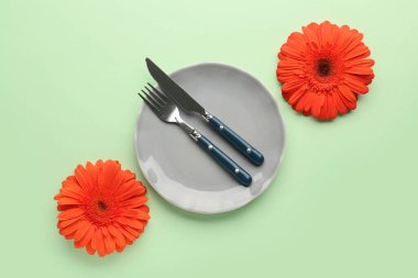 Yeşil arka planda güzel Gerbera çiçekleri olan masa ayarı