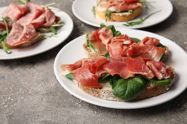 Lezzetli bruschetta tabakları ve grunge arkaplanda jambon.