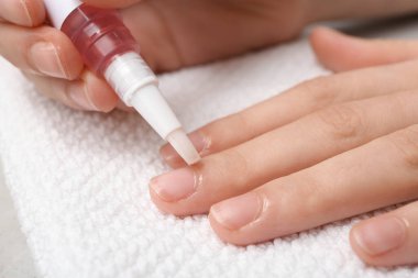 Beyaz havluyla tırnaklarına tırnak altı yağı süren kadın eller.