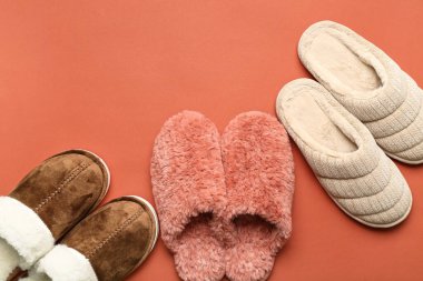 Kırmızı arka planda üç çift yumuşak terlik. Üst görünüm