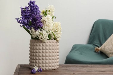 Odadaki masanın üstünde sümbül çiçekleri olan vazo.