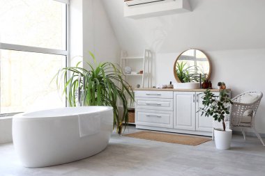 Banyonun içinde ayna, lavabo ve küvet var.