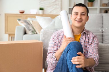 Genç adam evde streç film çekiyor.