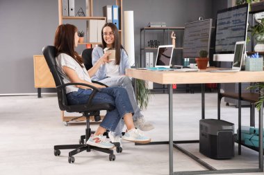 Ofiste çalışan kahve fincanları olan kadın programcılar.