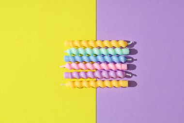 Renkli arkaplanda birçok doğum günü mumu