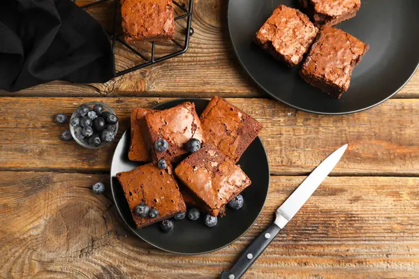 Ahşap zemin üzerinde lezzetli çikolatalı brownie parçaları olan bir tabak.