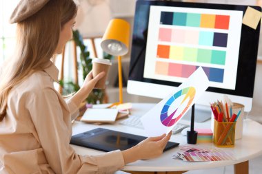 Ofisteki masada renk paletiyle çalışan kadın grafik tasarımcısı