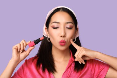 Leylak arkaplanda ruj izi olan güzel Asyalı kadın.