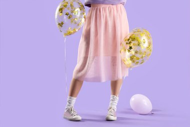 Leylak arka planda balonları olan genç bir kadın.