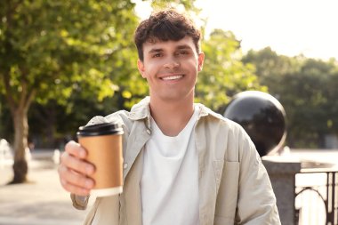 Bir fincan lezzetli latte ile yakışıklı bir genç adam.