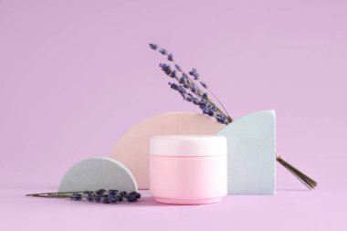Dekoratif podyumlar, kozmetik krem kavanozu ve leylak arkaplanlı lavanta çiçekleri.