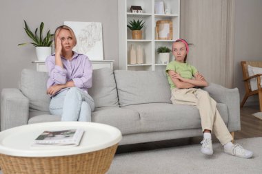 Üzgün genç kız, evde annesiyle kavga ettikten sonra kanepede oturuyor. Aile sorunları kavramı