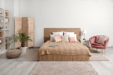 Konforlu yatağı ve şık koltuğu olan modern bir yatak odası.