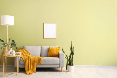 Gri kanepe, lamba ve boş çerçeveli oturma odasının içi.