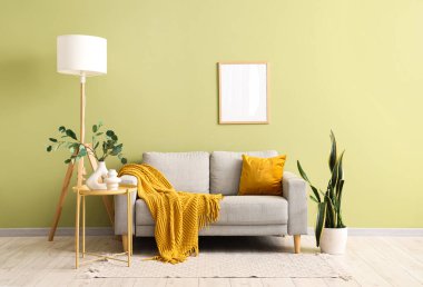 Gri kanepe, lamba ve boş çerçeveli oturma odasının içi.