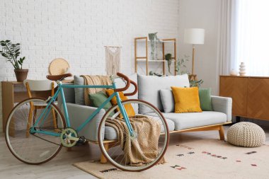 Oturma odasının içinde yastıklı, ekose ve bisikletli rahat bir kanepe.