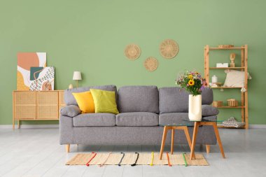 Oturma odasındaki sehpada yumuşak kanepe ve yabani çiçekler.