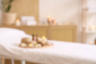 Masaj koltuğu ve yanan mumlarla aydınlık spa salonunun bulanık görüntüsü