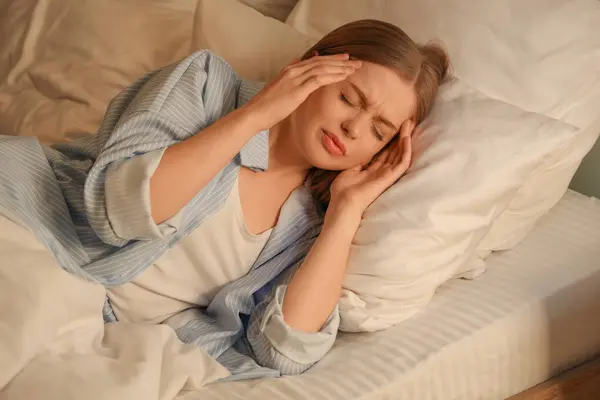 stock image Young woman suffering from insomnia in dark bedroom